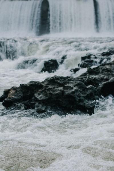 白天瀑布中黑岩的选择性聚焦摄影